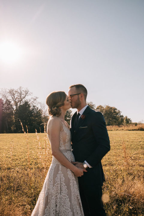 bride and groom field kiss portrait