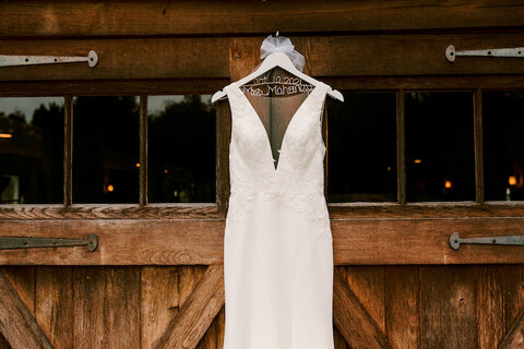 wedding dress hanging on barn door - 48 Fields Wedding Barn | Leesburg VA